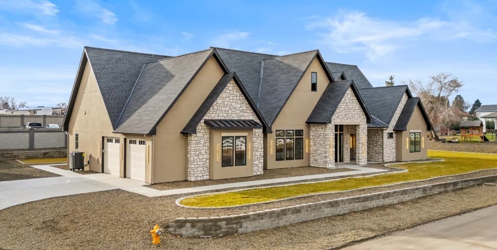 Modern Tri-Cities home with dark architectural shingles and stone exterior
