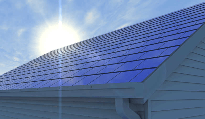 Home roof covered in glossy blue solar tiles under bright sun