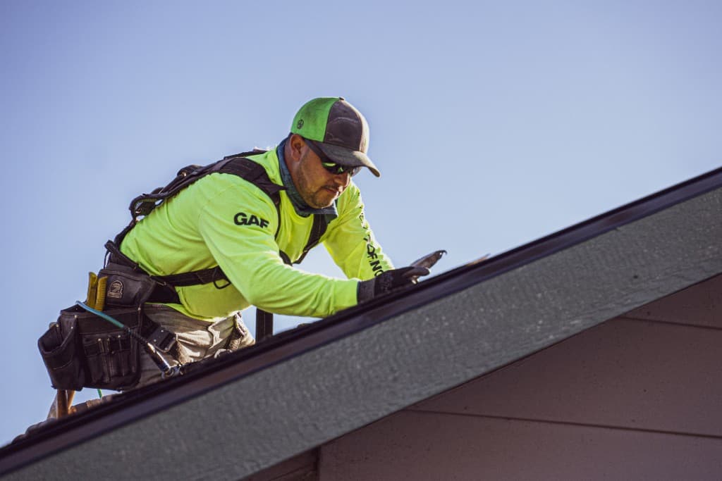 Eminent Roofing crew member in GAF gear working on a Tri-Cities residential roof